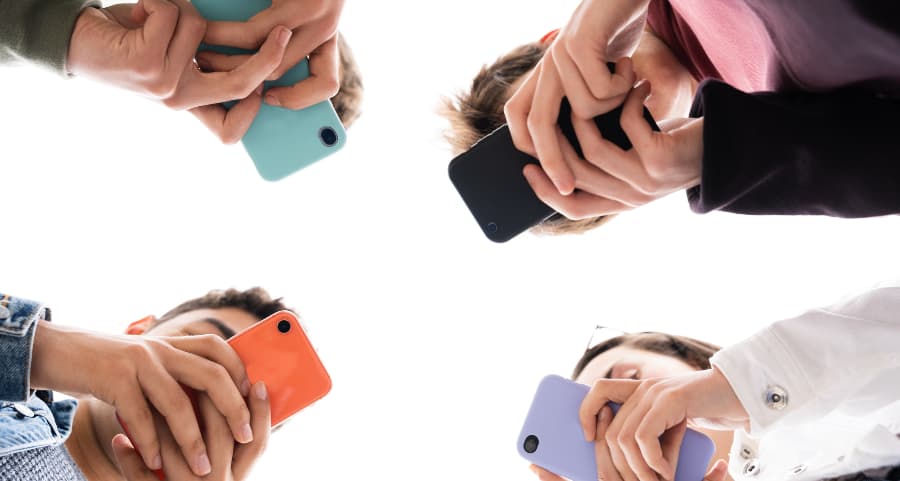 Teenagers using smartphones to access social media sites in